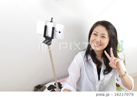 自撮り棒でセルフィーをしている日本人女性 自撮り棒でセルフィーをしている日本人女性 16217079