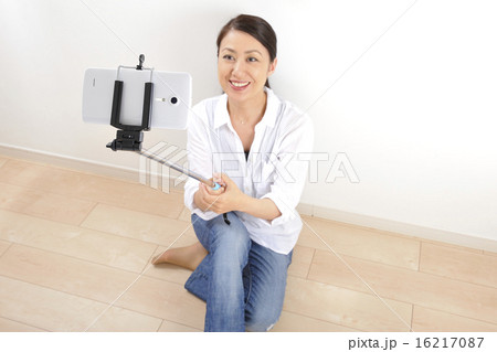 自撮り棒でセルフィーをしている日本人女性 16217087