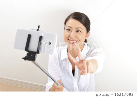 自撮り棒でセルフィーをしている日本人女性 自撮り棒でセルフィーをしている日本人女性 16217092