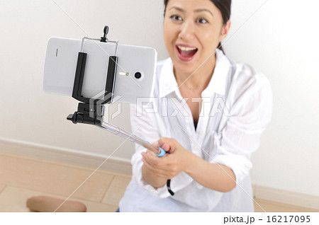 自撮り棒でセルフィーをしている日本人女性 16217095