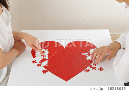 ハートのパズルを一緒に組み立てるカップル 16218056
