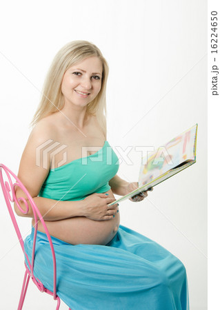 pregnant young woman sitting on chair and reading a book pregnant young woman sitting on chair and reading a book 16224650
