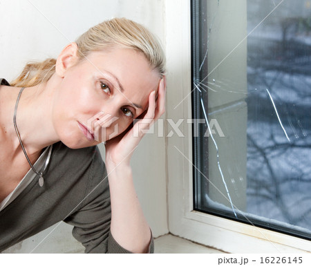 sad young woman near a window with the burst, brok sad young woman near a window with the burst, brok 16226145