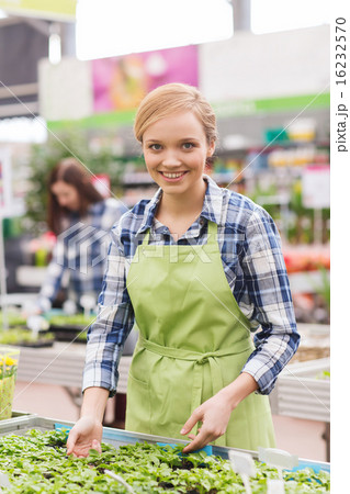 happy woman taking care of seedling in greenhouse 16232570