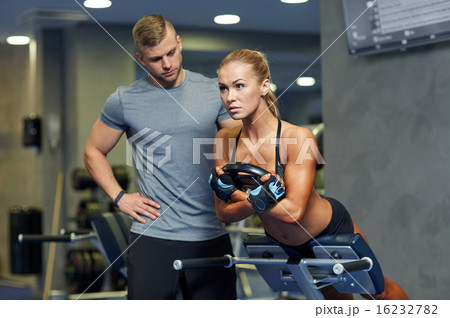 woman with personal trainer flexing muscles in gym woman with personal trainer flexing muscles in gym 16232782