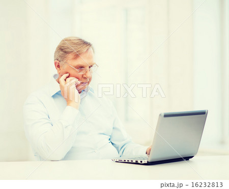 old man in eyeglasses working with laptop at home old man in eyeglasses working with laptop at home 16232813