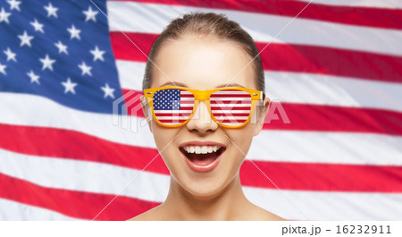 happy teenage girl in shades with american flag 16232911