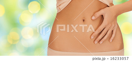 close up of woman pointing finger to bare belly 16233057