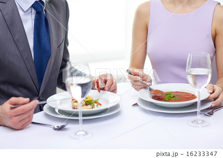 close up of couple eating appetizers at restaurant 16233347
