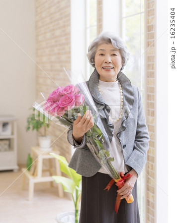 バラの花束を持つシニア女性の写真素材