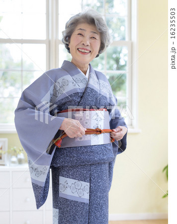 着物の帯紐を結ぶシニア女性 着物の帯紐を結ぶシニア女性 16235503