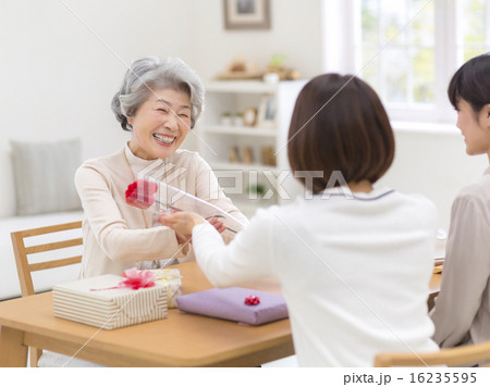 一輪の花を受け取る笑顔のシニア女性 一輪の花を受け取る笑顔のシニア女性 16235595