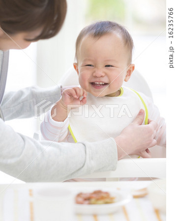 母親にスタイをつけてもらう赤ちゃん 16235766