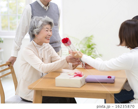 一輪の花を受け取る笑顔のシニア女性 一輪の花を受け取る笑顔のシニア女性 16235870