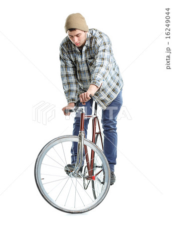 Young man doing tricks on fixed gear bicycle on a white 16249044