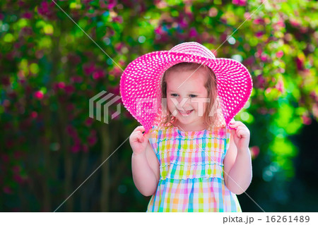 Little girl in a hat in blooming summer garden 16261489