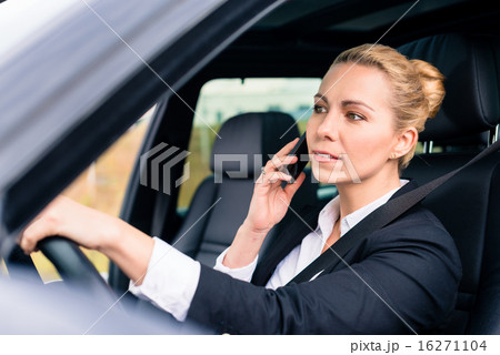 Woman using her phone while driving the car Woman using her phone while driving the car 16271104