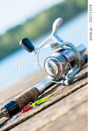 fishing rod on jetty close to lake fishing rod on jetty close to lake 16271428