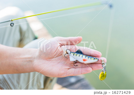 Fisher showing bait or lure at fishing rod Fisher showing bait or lure at fishing rod 16271429