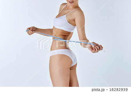 Woman holding meter measuring perfect shape of her beautiful body  16282939