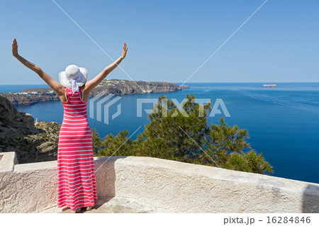 Woman in a long summer dress  watches the sea 16284846
