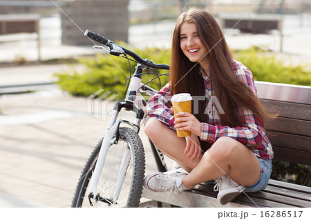 Young woman drinking coffee on a bicycle trip 16286517
