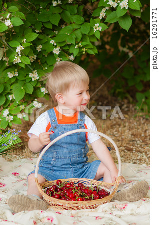 Little boy with a cherry in his hand in the summer Little boy with a cherry in his hand in the summer 16291771