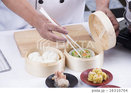 Chef using chopsticks hold Chinese dumpling 16310704
