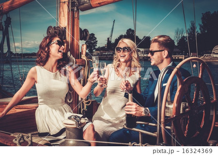 Stylish wealthy friends having fun on a luxury yacht Stylish wealthy friends having fun on a luxury yacht 16324369