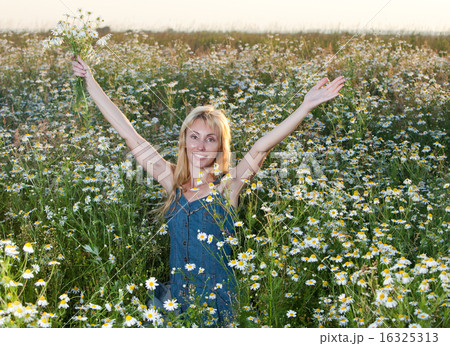 young woman in  field with a bouquet of camomiles 16325313