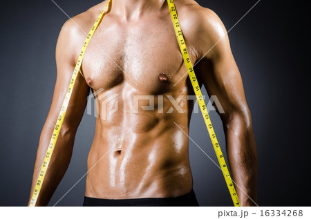 Muscular man measuring his muscles Muscular man measuring his muscles 16334268