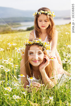 Two pretty girls at meadow with mountain view and flowers Two pretty girls at meadow with mountain view and flowers 16336605