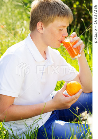 Teen boy is drinking glass with orange juice 16337286