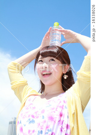 ペットボトルの水を飲む可愛い女の子の写真素材