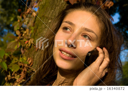 Beautiful girl says on the mobile 16340872