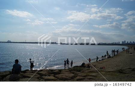 葛西臨海公園の砂浜で遊ぶファミリーと東京の景色の写真素材