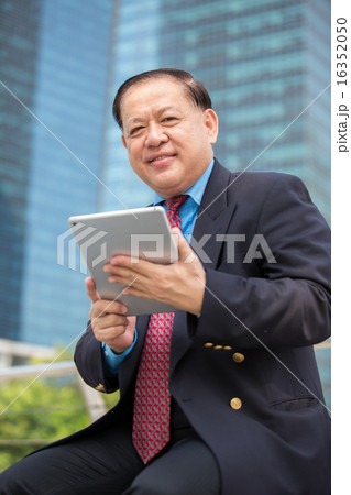 Asian senior businessman in suit using tablet 16352050