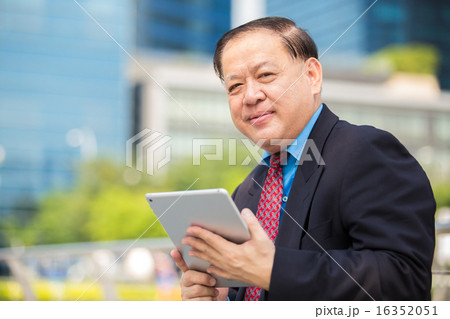 Asian senior businessman in suit using tablet 16352051