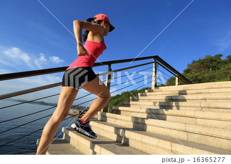 sports woman running up on stone stairs seaside 16365277