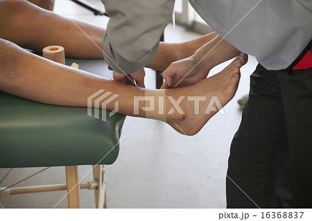 足首にテーピングを受ける男性の画像の写真素材