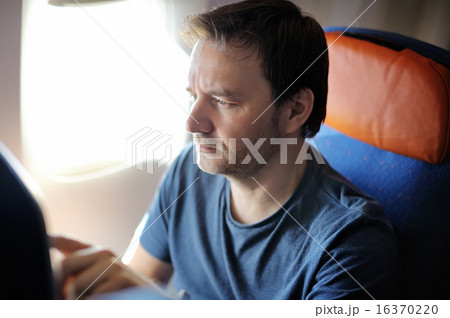 Male passenger holding passport and boarding pass Male passenger holding passport and boarding pass 16370220