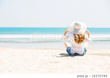 Beautifil young woman sitting on the beach at sunny day enjoing summer vacation 16370789