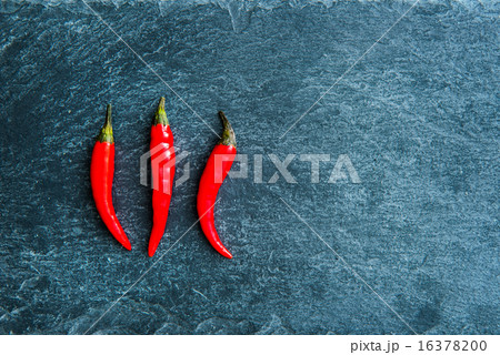 Closeup on red chili peppers on stone substrate Closeup on red chili peppers on stone substrate 16378200