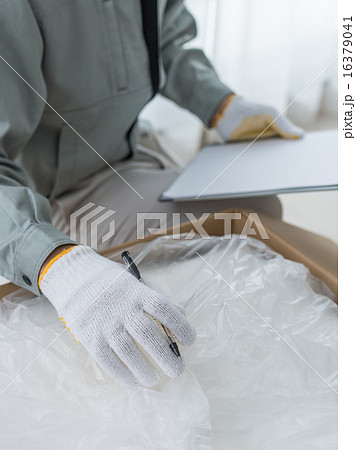 作業員が納品書にサインする様子 作業員が納品書にサインする様子 16379041