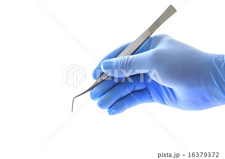 ピンセットを持つ歯科医師の手の写真素材