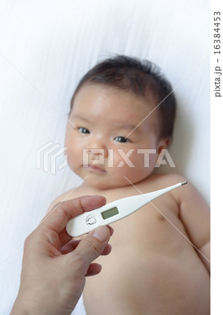 赤ちゃんの熱を測るお母さんの手 16384453