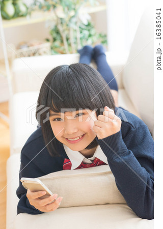 スマホを持ってガッツポーズをする中学生 16385041