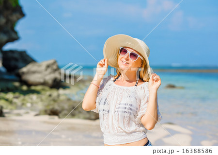 Colorful portrait of young pretty girl at the beach with blue sky on background. Travel, vacation 16388586