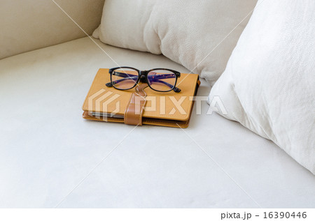 Diary with glasses on the sofa in in living room Diary with glasses on the sofa in in living room 16390446