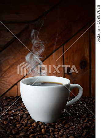 white cup on coffee beans on wooden background white cup on coffee beans on wooden background 16397628